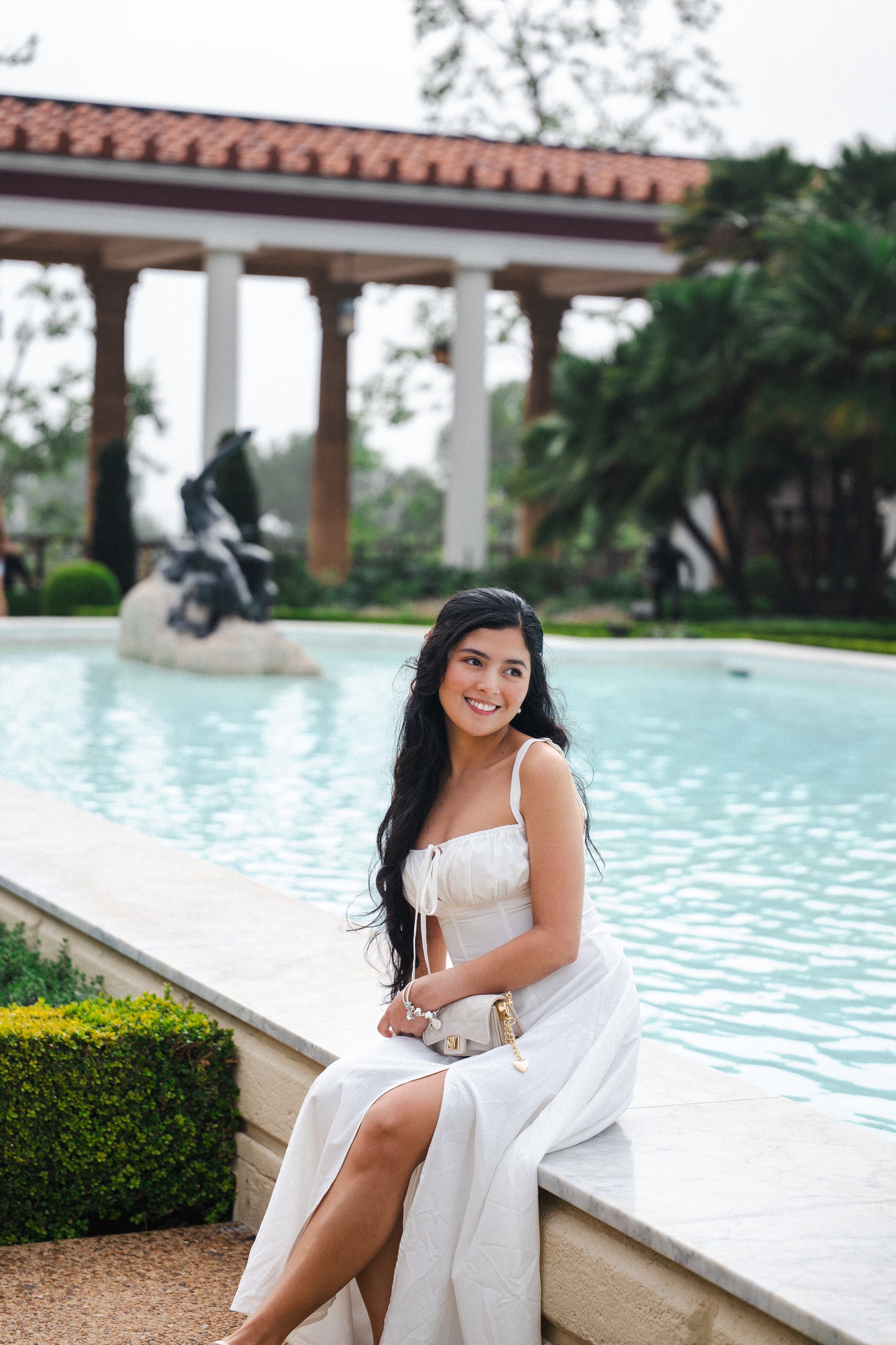 Seychelle in a white dress beside the Outer Peristyle fountain at the Getty Villa